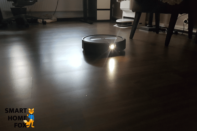Man sieht den iRobot Roomba j7+ dankt seiner Lampe bei schlechten Lichtverhältnissen die Wohnung reinigen.